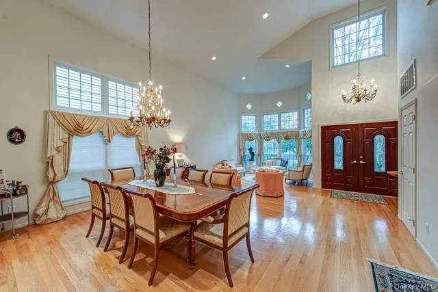 a dining room with furniture a chandelier and wooden floor