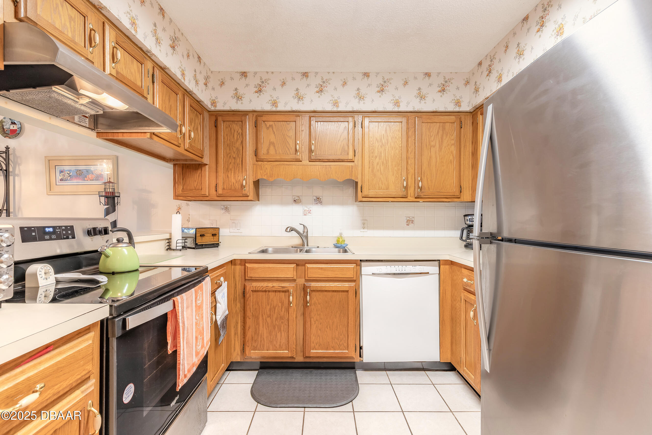 2222 Ocean Shore Boulevard, Unit 402B Ormond Beach, FL 32176 - Photo 14 of 31 a kitchen with a refrigerator a sink and dishwasher