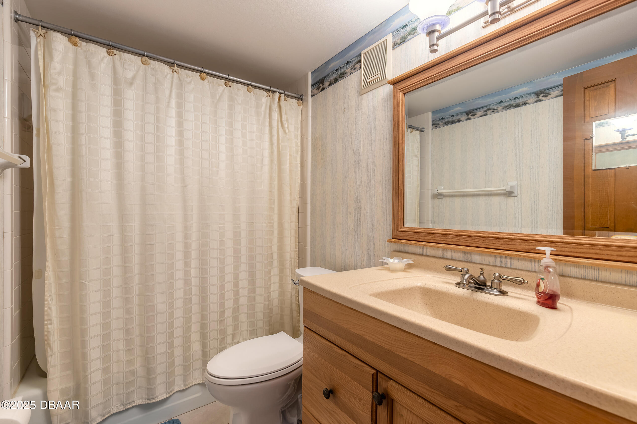 2222 Ocean Shore Boulevard, Unit 402B Ormond Beach, FL 32176 - Photo 20 of 31 a bathroom with a sink a toilet and a mirror