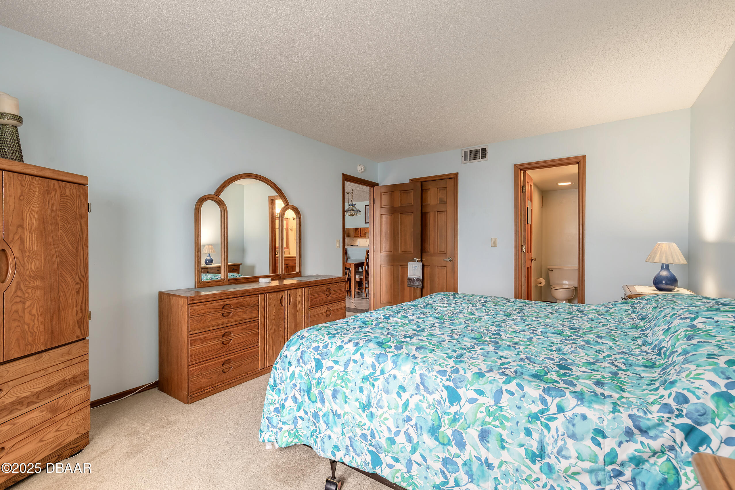2222 Ocean Shore Boulevard, Unit 402B Ormond Beach, FL 32176 - Photo 22 of 31 a bedroom with a bed and a dresser