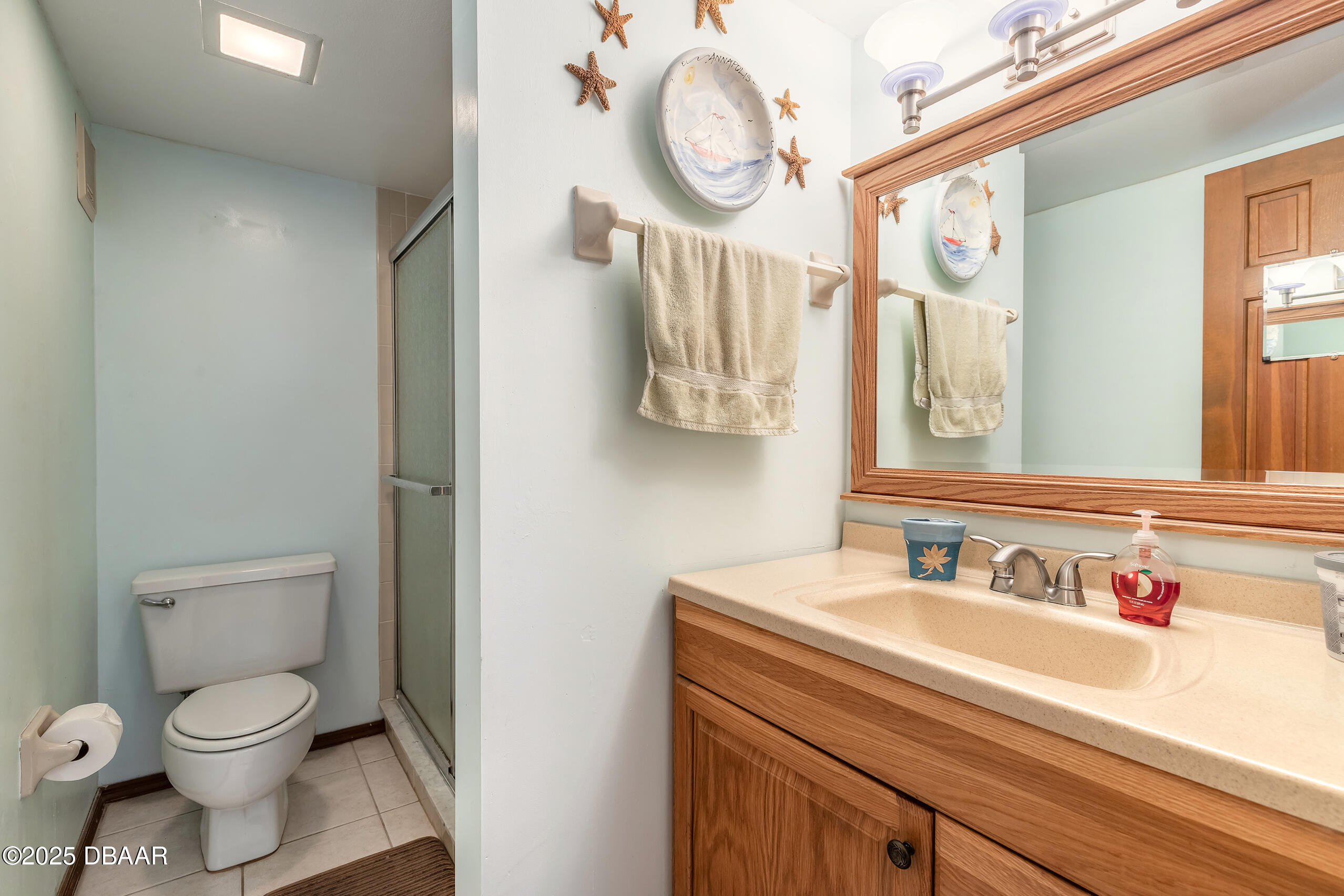 2222 Ocean Shore Boulevard, Unit 402B Ormond Beach, FL 32176 - Photo 23 of 31 a bathroom with a toilet sink and mirror