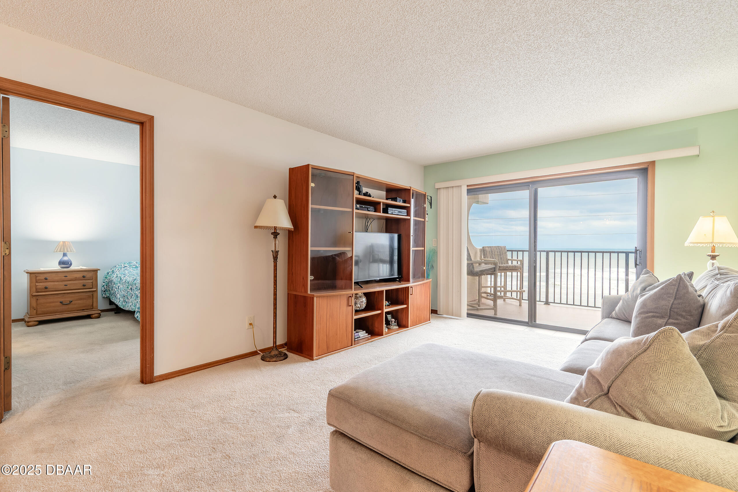2222 Ocean Shore Boulevard, Unit 402B Ormond Beach, FL 32176 - Photo 26 of 31 a bedroom with furniture and a flat screen tv
