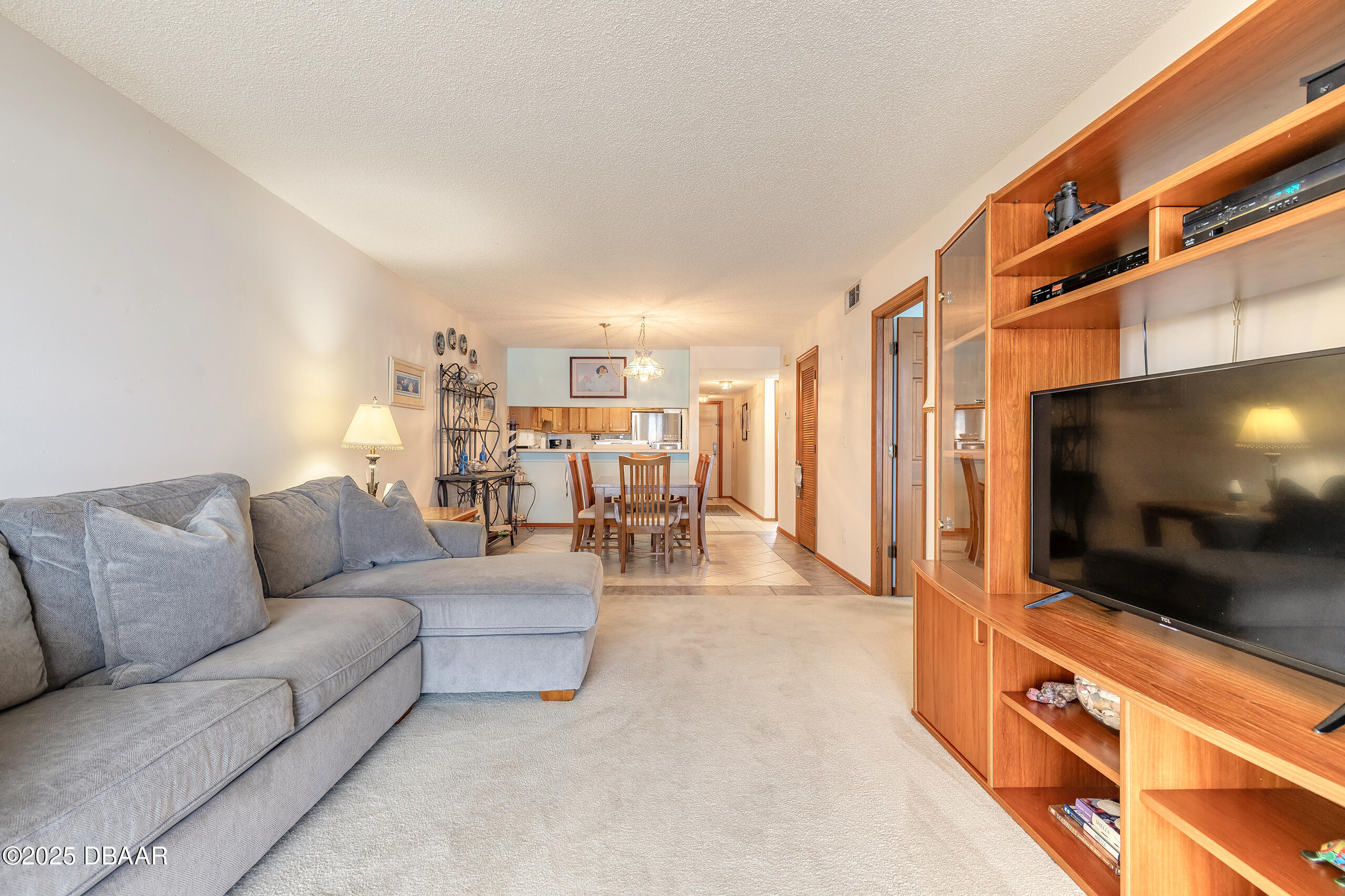 2222 Ocean Shore Boulevard, Unit 402B Ormond Beach, FL 32176 - Photo 31 of 31 a living room with furniture and a flat screen tv