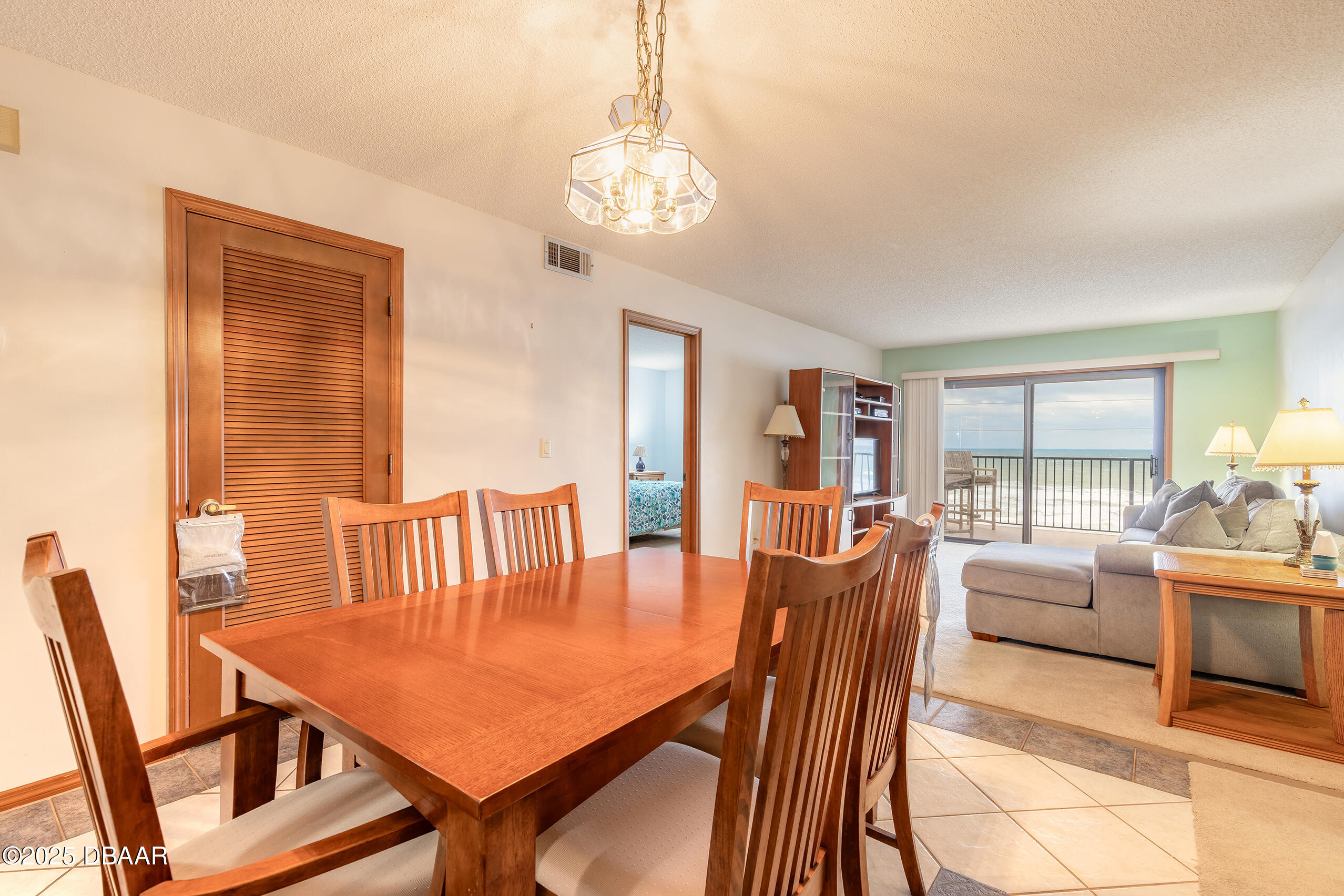 2222 Ocean Shore Boulevard, Unit 402B Ormond Beach, FL 32176 - Photo 28 of 31 a view of a dining room with furniture wooden floor and a chandelier