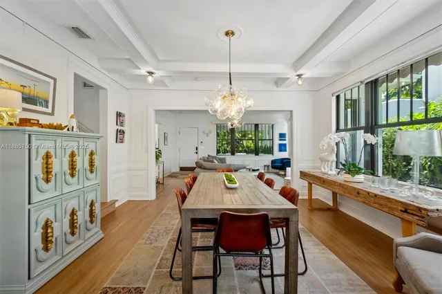 a view of a dining room with furniture a chandelier and wooden floor