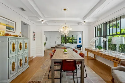 a view of a dining room with furniture a chandelier and wooden floor