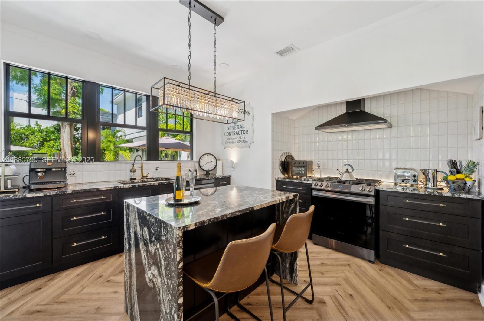 135 Northeast 45th Street Miami, FL 33137 - Photo 16 of 48 a kitchen with a stove a sink a dining table and chairs
