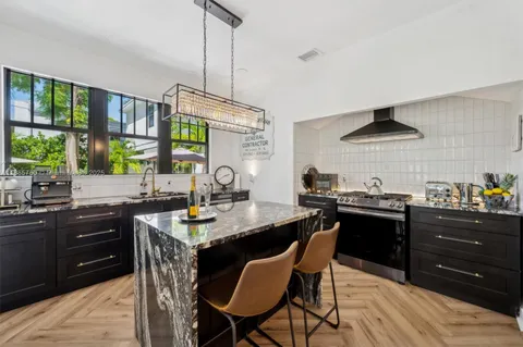 a kitchen with a stove a sink a dining table and chairs