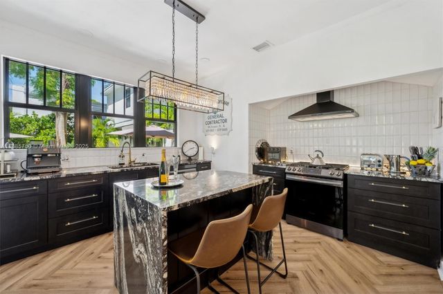 a kitchen with a stove a sink a dining table and chairs