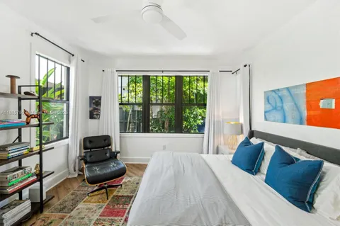 a bedroom with furniture and a large window