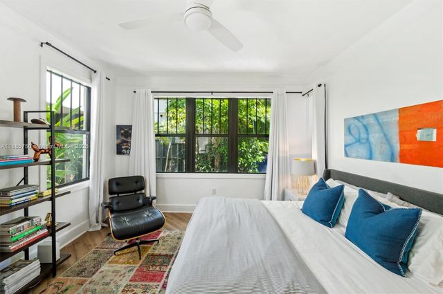 a bedroom with furniture and a large window