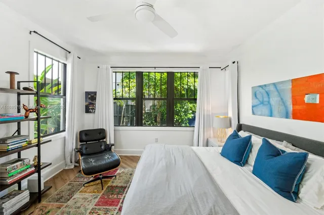 a bedroom with furniture and a large window