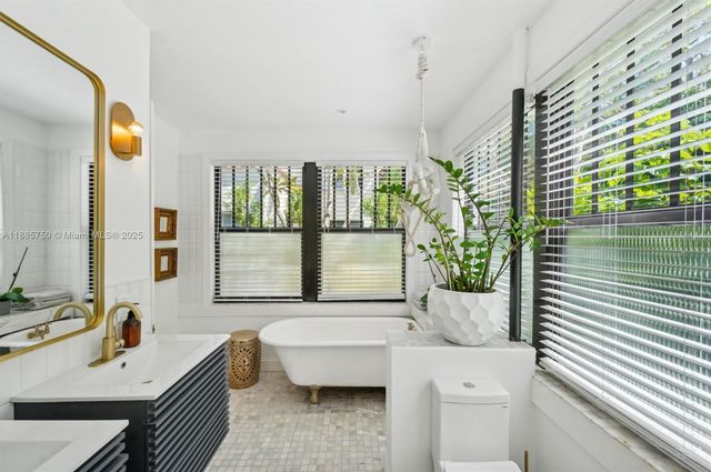 a bathroom with a tub sink and mirror
