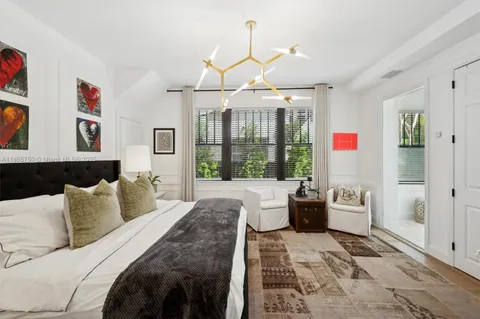 a bedroom with a balcony a bed and a chandelier