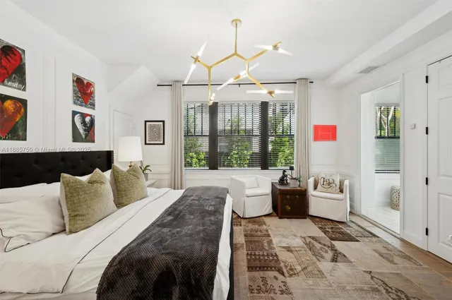 a bedroom with a balcony a bed and a chandelier