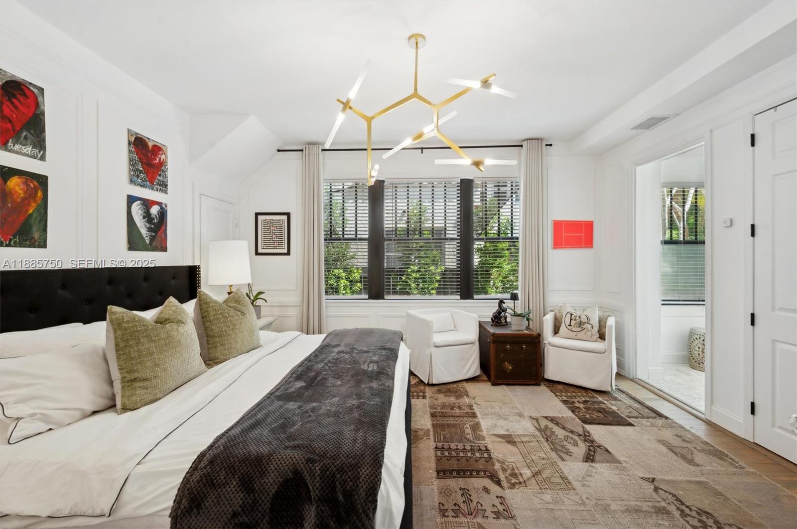 135 Northeast 45th Street Miami, FL 33137 - Photo 23 of 48 a bedroom with a balcony a bed and a chandelier