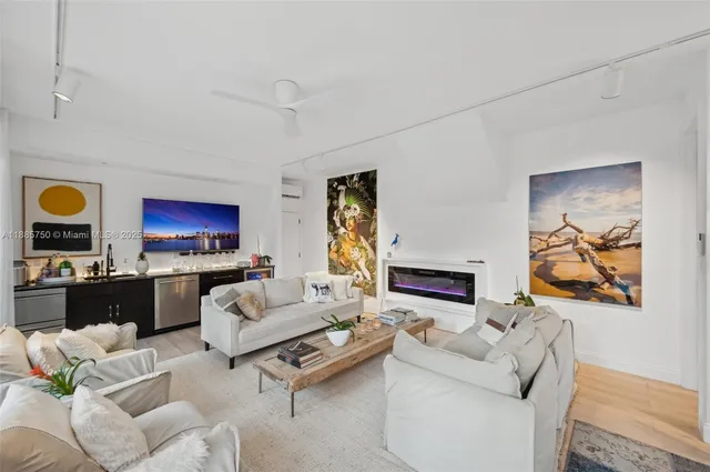 a living room with furniture a flat screen tv and a fireplace