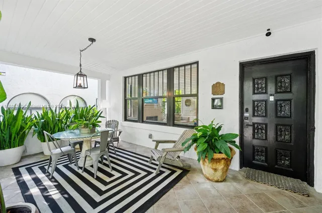 a vase of flowers sitting on a table in front of a window