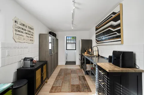 a hallway with a computer on a table and wooden floor