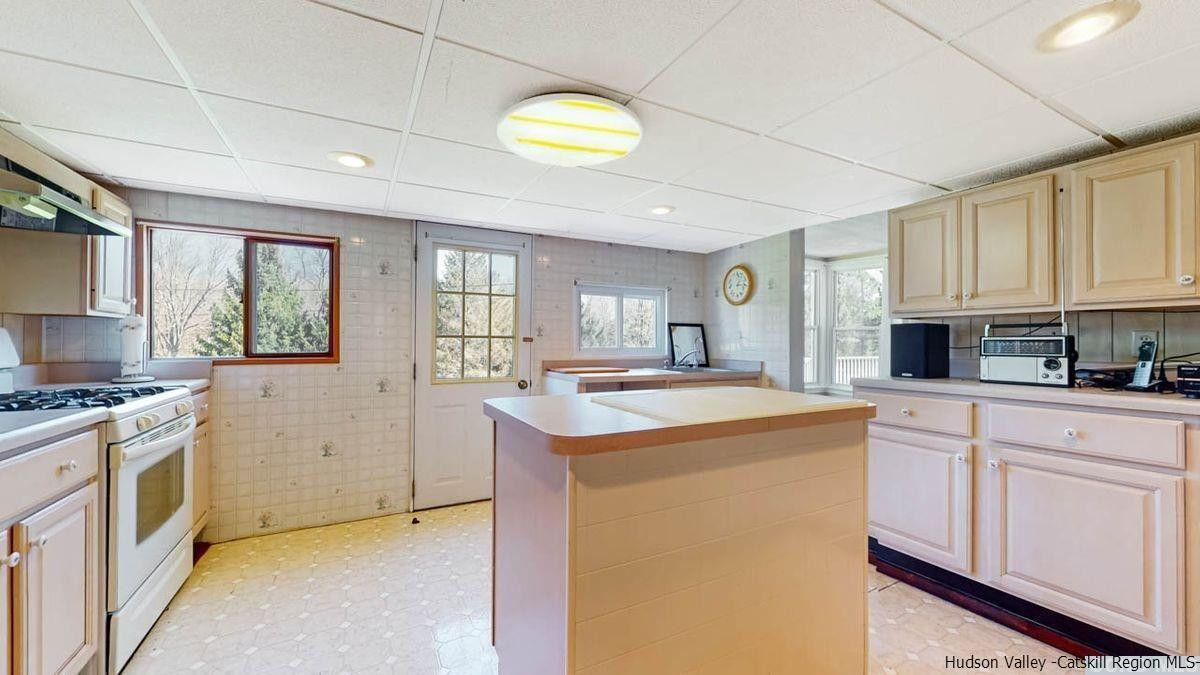 53 Pine Valley Road Greenville, NY 12083 - Photo 6 of 35 a kitchen with a stove a sink a refrigerator cabinets and a window