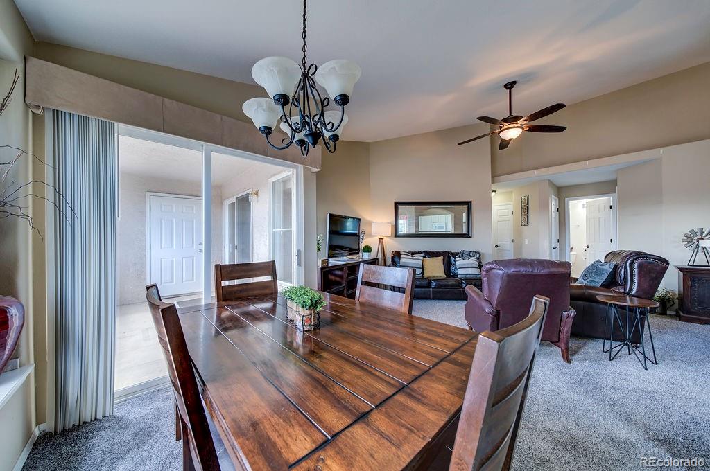3875 Strawberry Field Grove Colorado Springs, CO 80906 - Photo 24 of 50 a view of a dining room with furniture a chandelier and wooden floor