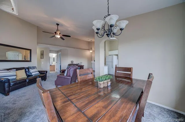 a view of a dining room with furniture a chandelier and wooden floor