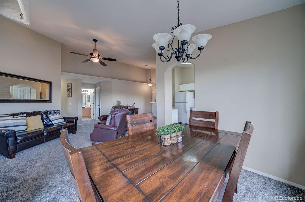 3875 Strawberry Field Grove Colorado Springs, CO 80906 - Photo 25 of 50 a view of a dining room with furniture a chandelier and wooden floor