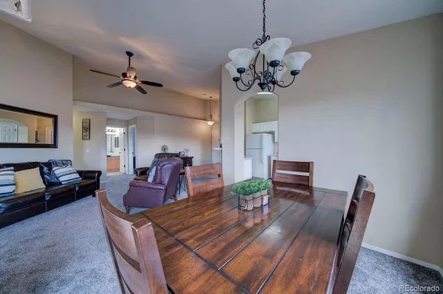 a view of a dining room with furniture a chandelier and wooden floor
