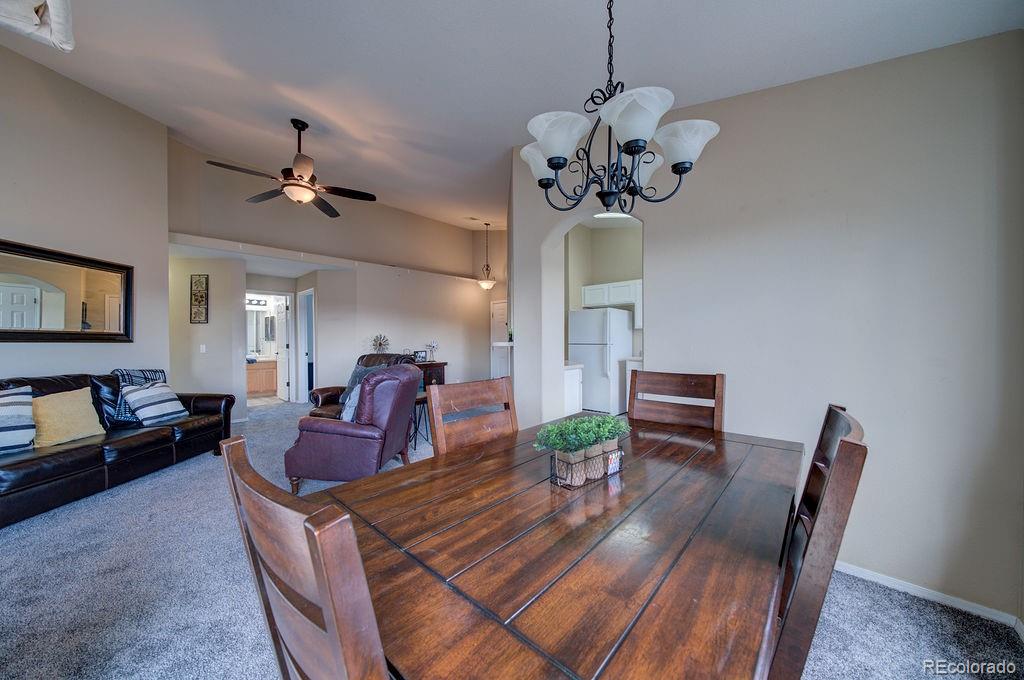 3875 Strawberry Field Grove Colorado Springs, CO 80906 - Photo 26 of 50 a view of a dining room with furniture a chandelier and wooden floor