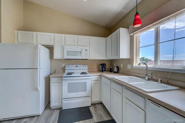 a kitchen with sink refrigerator and cabinets