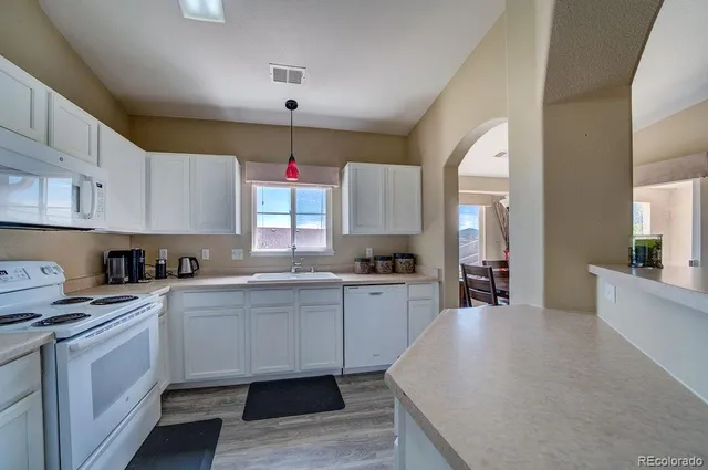 a kitchen with granite countertop a sink and cabinets