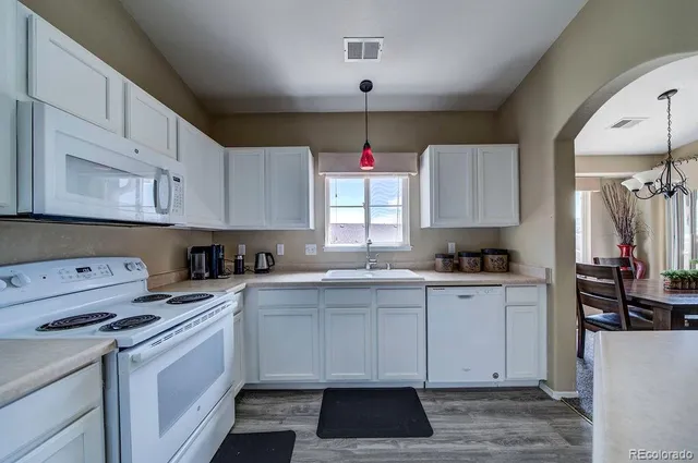 a kitchen with cabinets appliances a sink and a window