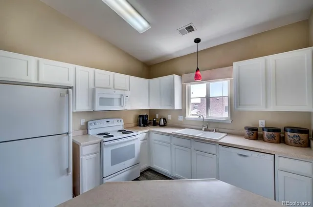 a kitchen with a sink window and cabinets