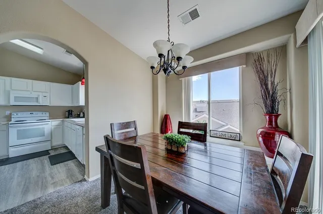 a view of a dining room with furniture and a chandelier