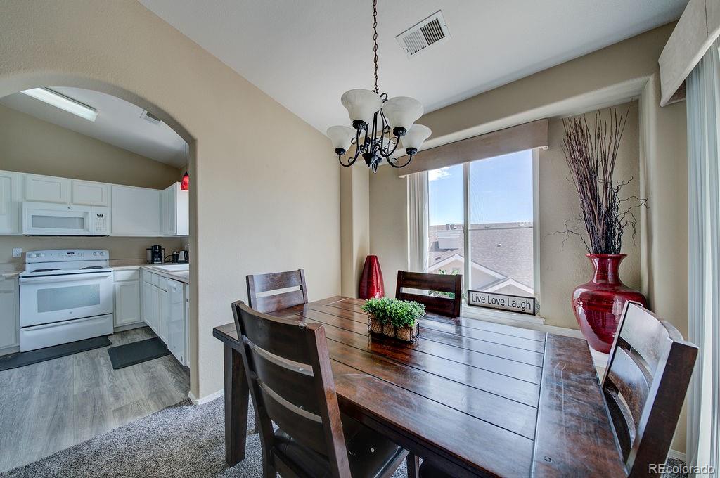 3875 Strawberry Field Grove Colorado Springs, CO 80906 - Photo 42 of 50 a view of a dining room with furniture and a chandelier
