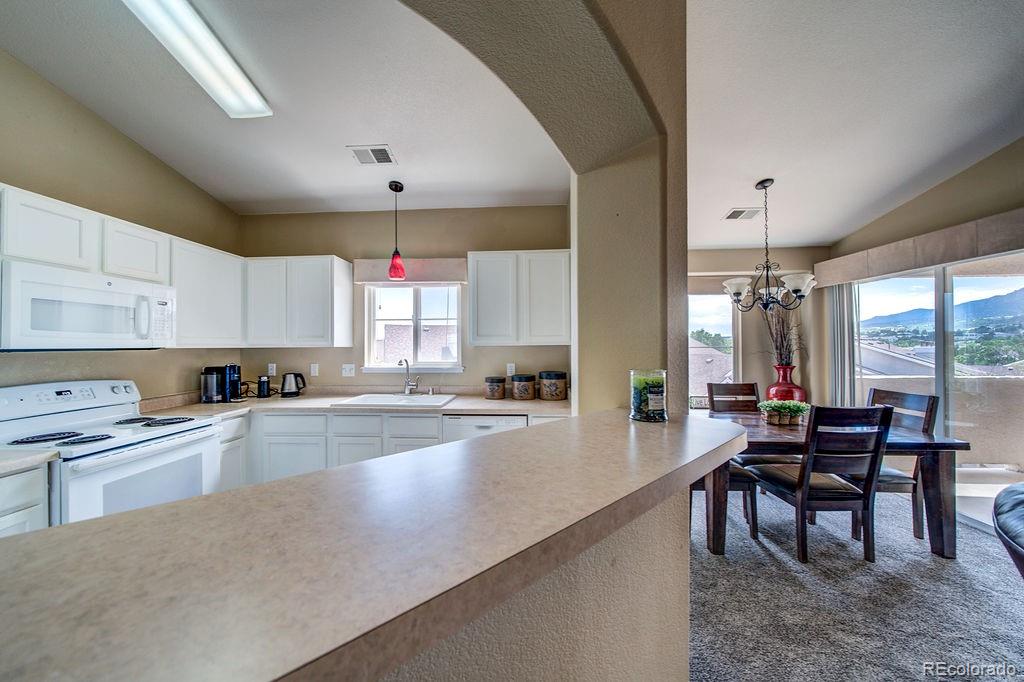 3875 Strawberry Field Grove Colorado Springs, CO 80906 - Photo 44 of 50 a large kitchen with kitchen island a large window in it