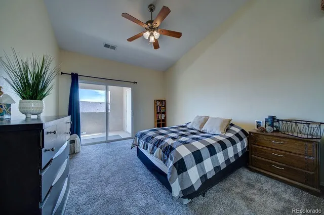 a spacious bedroom with a bed and a chandelier