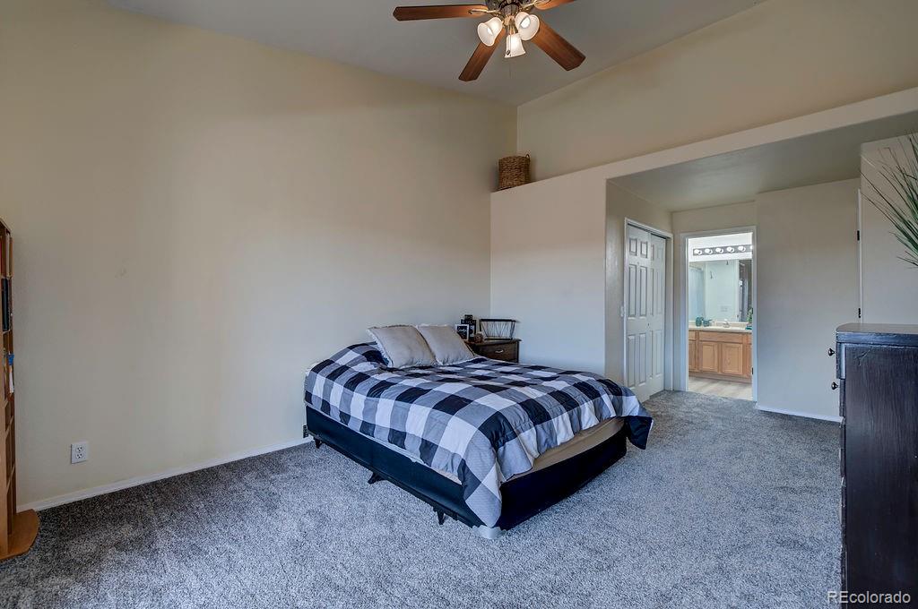 3875 Strawberry Field Grove Colorado Springs, CO 80906 - Photo 49 of 50 a spacious bedroom with a bed and a chandelier