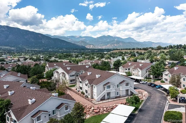 an aerial view of residential houses with outdoor space and city view