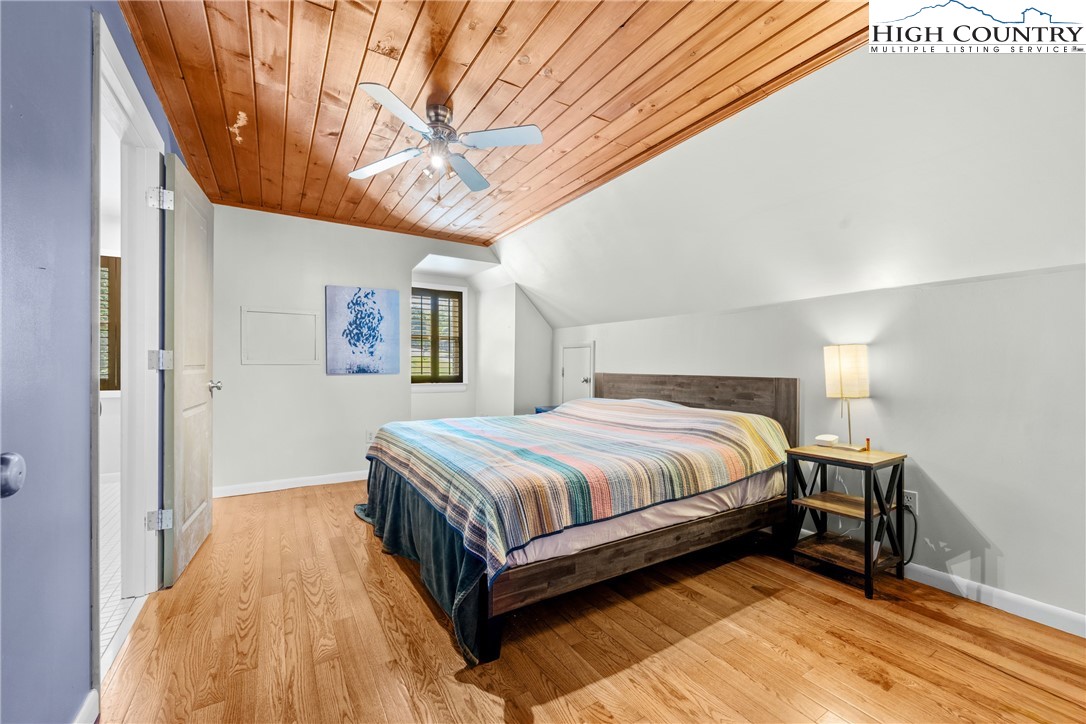 239 Deerfield Estates Road Boone, NC 28607 - Photo 16 of 45 a bedroom with a bed and a chandelier