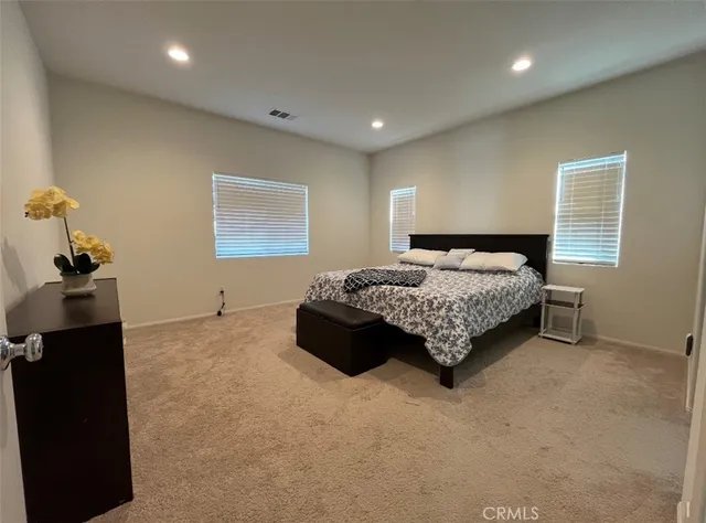 a spacious bedroom with a bed and a window