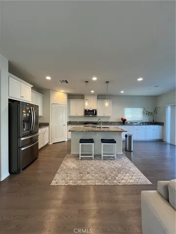 a kitchen with a refrigerator a stove top oven and kitchen island