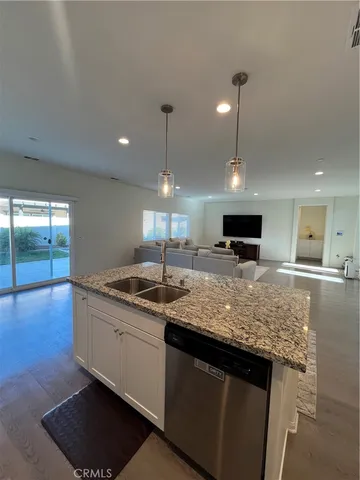 a kitchen with granite countertop kitchen island a sink appliances and a counter top space