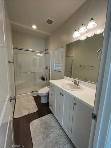 a bathroom with a double vanity sink mirror and toilet