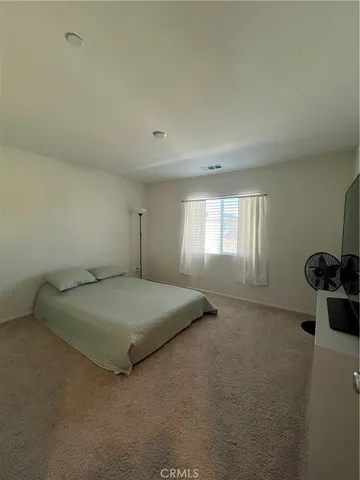 a spacious bedroom with a bed and window