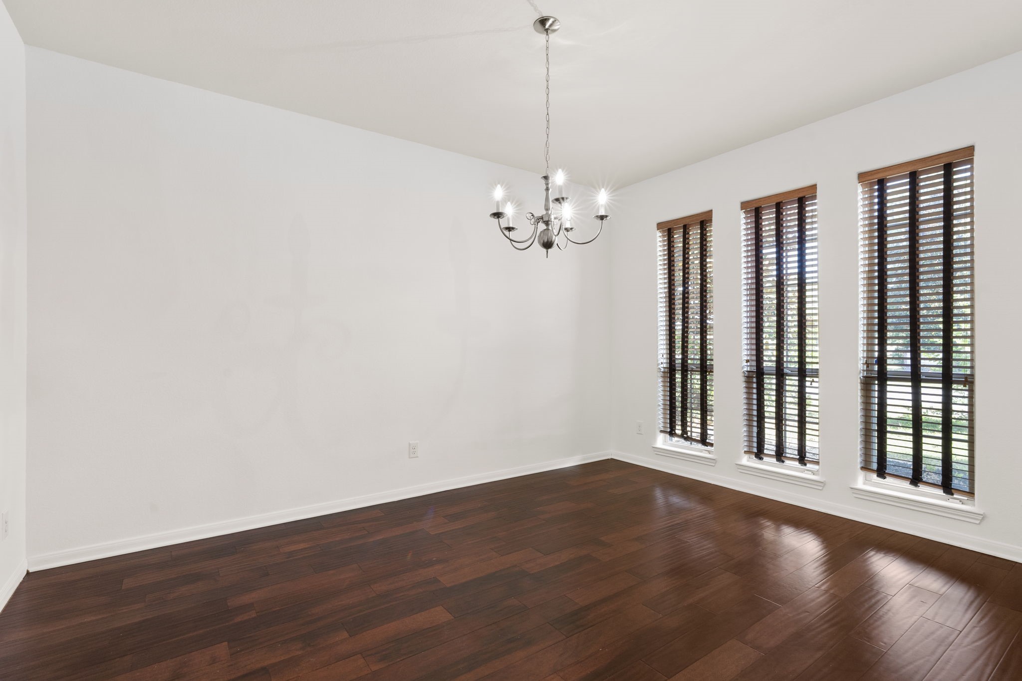 20555 Bonds Creek Lane Spring, TX 77388 - Photo 5 of 34 an empty room with wooden floor chandelier and windows