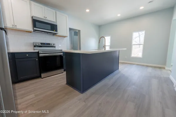 a kitchen with stainless steel appliances granite countertop a sink a stove top oven a counter space and cabinets