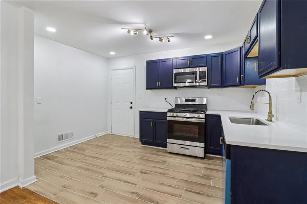 3159 Bobolink Drive Decatur, GA 30032 - Photo 7 of 37 a kitchen with stainless steel appliances a stove sink microwave and cabinets