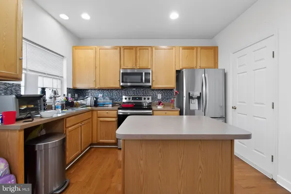 a kitchen with stainless steel appliances a refrigerator sink stove microwave and cabinets