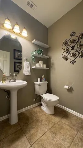 a bathroom with a sink toilet and a mirror